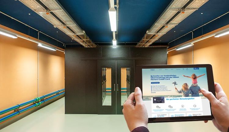 Serverraum im PLANET IC Rechenzentrum, im Vordergrund ein Tablet mit der Hilton-Credit-Card-Website